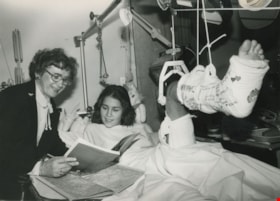 Olga Kotelko reading to girl with a broken leg, ca.1980 thumbnail