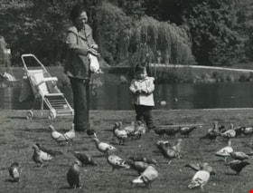 Woman and child feeding pigeons in the park, 1983 thumbnail