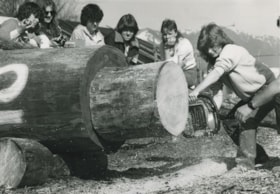 Maureen Demson cutting wood with a chainsaw, ca.1983 thumbnail