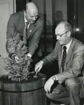 Two men planting a tree indoors, ca.1983 thumbnail
