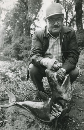 A man holding a shark he just caught, ca.1982 thumbnail
