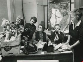 Women around a desk with a box full of toy donations, ca.1982 thumbnail