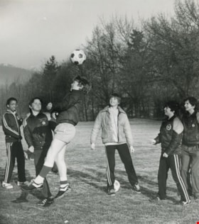 A group of young boys playing soccer in the field, [1982] thumbnail