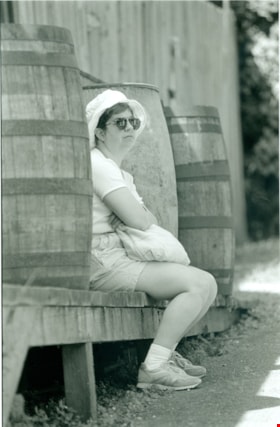 Woman sitting by barrels, July , 1996 thumbnail
