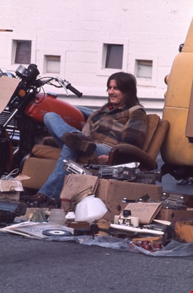 Person seated in chair at swap meet, Spring 1974 thumbnail