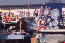 Woman with toys and crocheted items at swap meet, Spring 1974 thumbnail