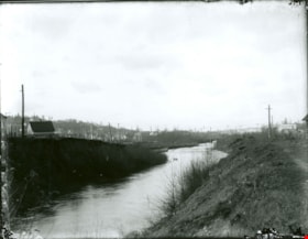 Community along the bank of a creek, [between 1900 and 1915] thumbnail