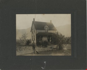 Man and his dog in front of a house, [190-] thumbnail