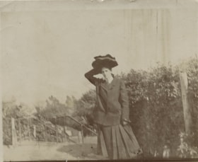 Young woman hanging onto her hat, [1900] thumbnail