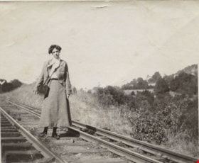 Young woman standing on a railway track, [190-] thumbnail