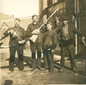 Four men on a cobblestone street, [190-] thumbnail