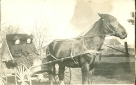 Two women in a horse-drawn wagon, [190-] thumbnail