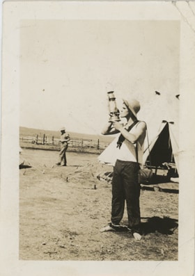 MacPherson lighting a cigarette from lantern, 1936 thumbnail