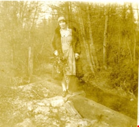Marion Kidd standing on a fallen log, [192-] thumbnail