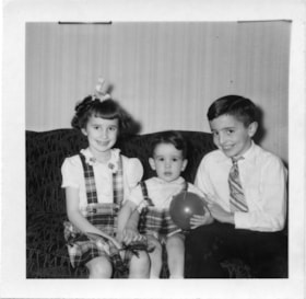 Three children seated on couch, [between 1940 and 1960] thumbnail