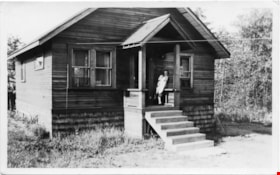 Woman holding small baby on porch of house, [between 1940 and 1950] thumbnail