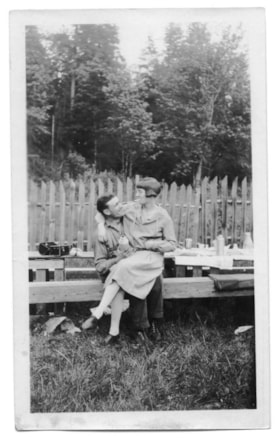 A man and woman seated together on a wooden beam, [between 1920 and 1930] thumbnail