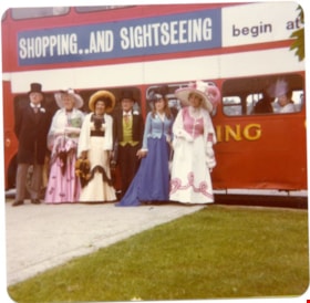 Confederation Singers standing in front of a red double decker bus., 1970-1980 thumbnail