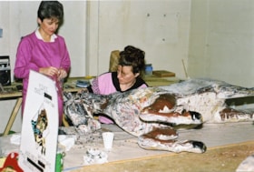 Volunteers stripping paint from carousel horses, [between 1990 and 1992] thumbnail