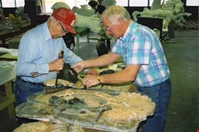 Restoration volunteers making repairs to decorative shield on carousel, [between 1990 and 1992] thumbnail