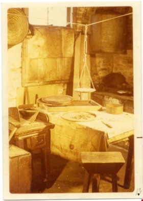Way Sang Yuen Wat Kee & Co. kitchen with table, stool, and scale hanging from line, 1975 thumbnail