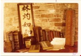 Shelf of books with two Chinese signs, 1975 thumbnail