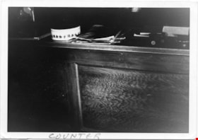 Wooden counter with round tin and papers, 1975 thumbnail