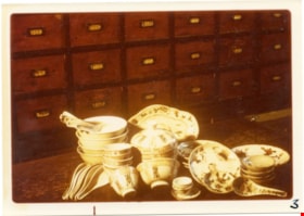Dishes with Chinese characters on wooden counter, 1975 thumbnail