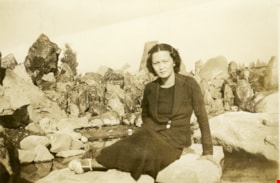 Suey Ying Jung (Laura) sitting in front of rocks, [between 1950 and 1955] thumbnail