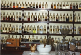 Apothecary bottles and artifacts inside Burnaby Village Museum Pharmacy, [198-] thumbnail