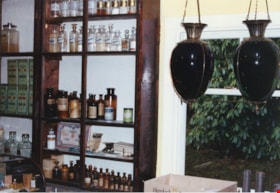 Apothecary bottles and show globes inside Burnaby Village Museum Pharmacy, [198-] thumbnail