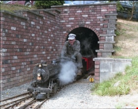 Model train coming through tunnel, [between 1975 and 1979] thumbnail