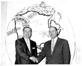 Haskell shaking hands with Al Moore in front of map, [1954] thumbnail
