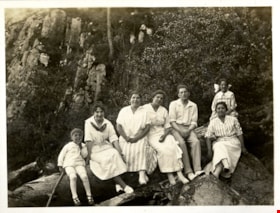 Group of seven people sitting on log, [191-] thumbnail