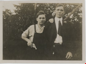 Bob Love holding hand gun and standing next to young man, [190-] thumbnail