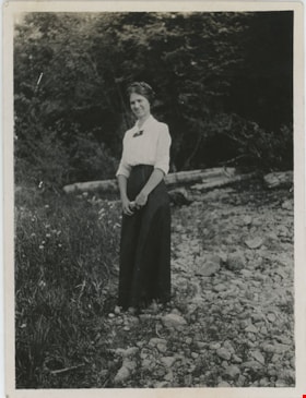 Woman standing on rocky shore, [191-] thumbnail