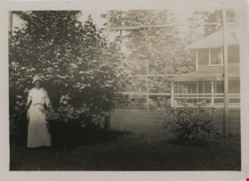 Woman standing in front of tree, [192-] thumbnail