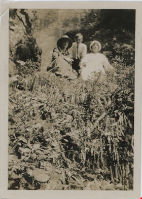 Two women and young man on hillside, [191-] thumbnail