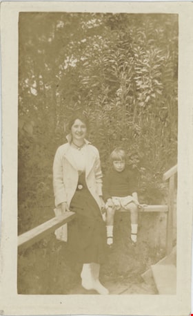 Woman and child seated on railing, [191-] thumbnail