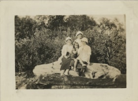 Three women and child on log, [192-] thumbnail
