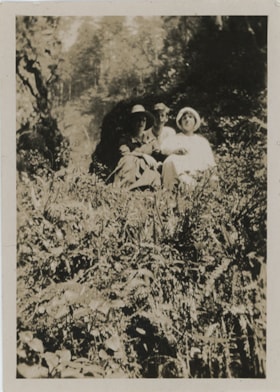 Two women and young man on hillside, [191-] thumbnail