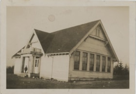Child standing on porch of house or school, [192-] thumbnail