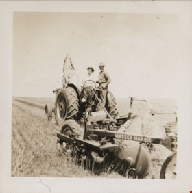 Woman and man on tractor in field, [194-] thumbnail